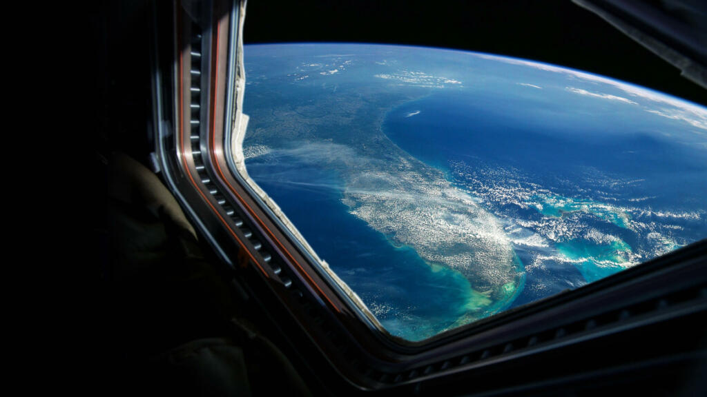 Spaceship flies near the amazing blue planet earth, view from the window. Travel and tourists in space, concept. Beautiful space view of the Earth with cloud formation. Hotel in space