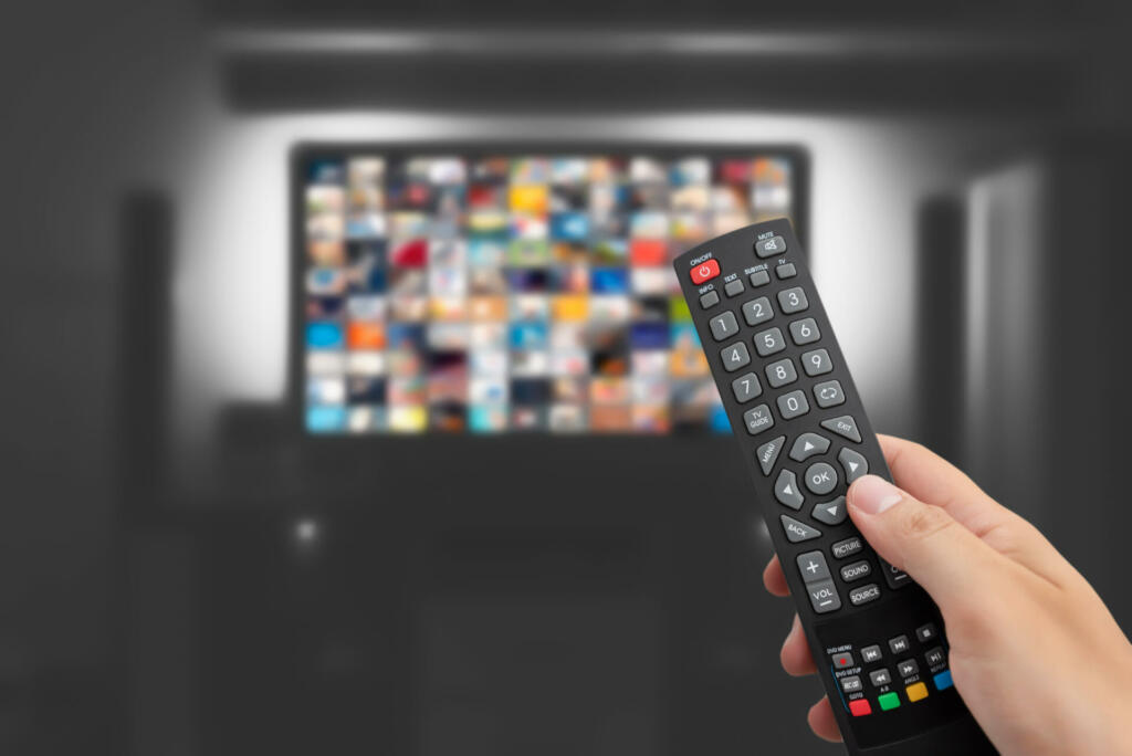 Video on demand, TV streaming, multimedia. Hand holding remote control