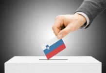 Bomo šli še tretjič na referendum o evtanaziji? Voting concept - Male inserting flag into ballot box - Slovenia