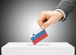 Bomo šli še tretjič na referendum o evtanaziji? Voting concept - Male inserting flag into ballot box - Slovenia