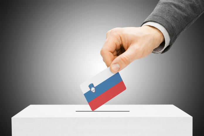 Voting concept - Male inserting flag into ballot box - Slovenia