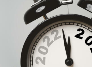 2022 and 2023 on black alarm clock for preparation Merry Christmas and Happy new year concept.