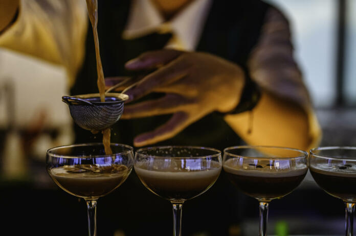 Bartender making alcoholic cocktail at the bar.