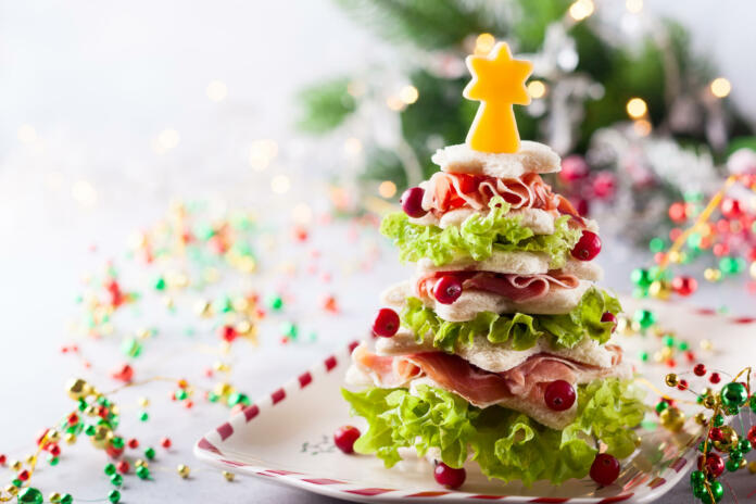 Christmas tree from toasted bread, lettuce, ham and cheese. Festive idea for Christmas or New Year dinner.