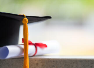 Kakovostna in poceni vezava diplomskih, magistrskih in doktorskih nalog, tudi A3 format Close-up of a mortarboard and degree certificate put on the table. Education stock photo