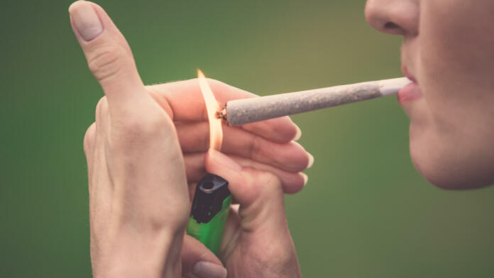 Close-up of woman smoking marijuana cannabis joint