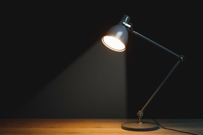 desk lamp with spotlight, black background with copy-space