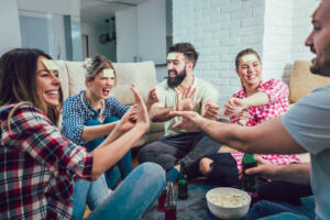 Diverse people playing game guess who and having fun at home