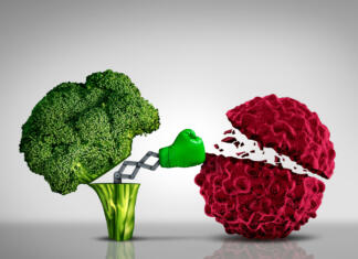 Solata na dan odžene raka črevesja stran? Health food and Cancer fighting foods nutrition concept with a green boxing glove emerging out of an open broccoli vegetable as a health care metaphor for a healthy lifestyle diet rich in natural fruit and vegetables to attack tumors and fight illness.