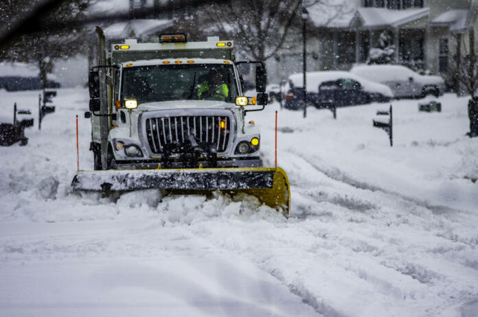 Heavy equipment driver working to push snow to the side of the streets after a blizzard