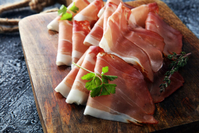 Italian prosciutto crudo or jamon with parsley. Raw ham.