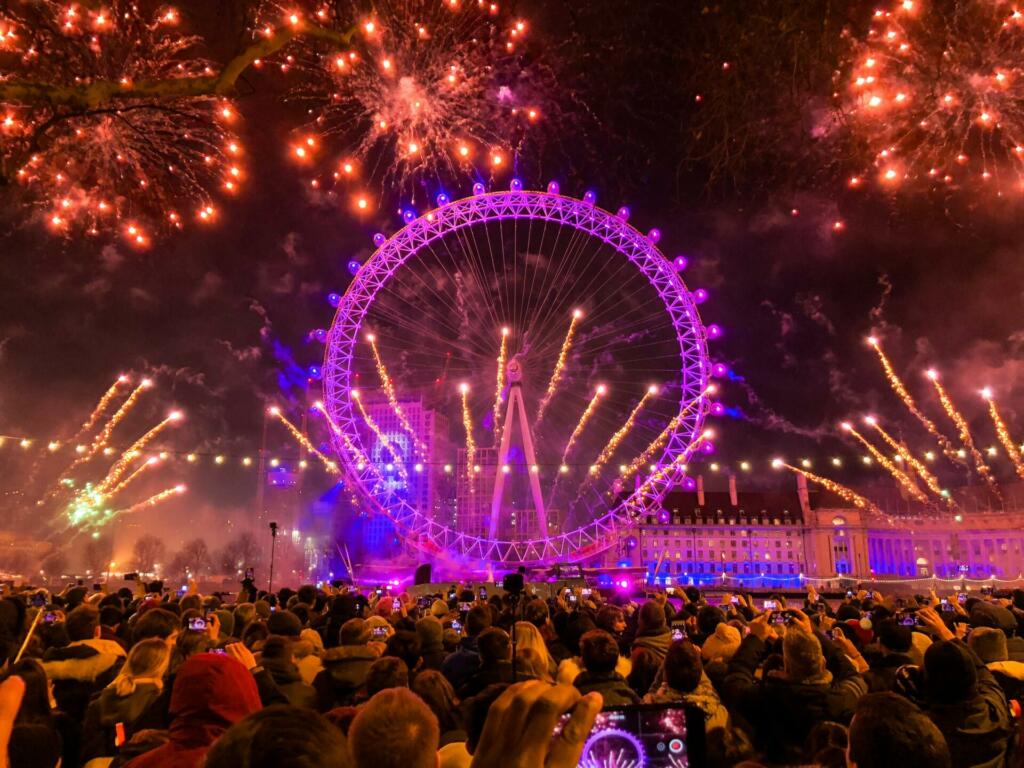 Množica ljudi, ognjemet in osvetljen London Eye