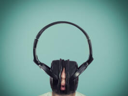 Man listening music on huge headphones .