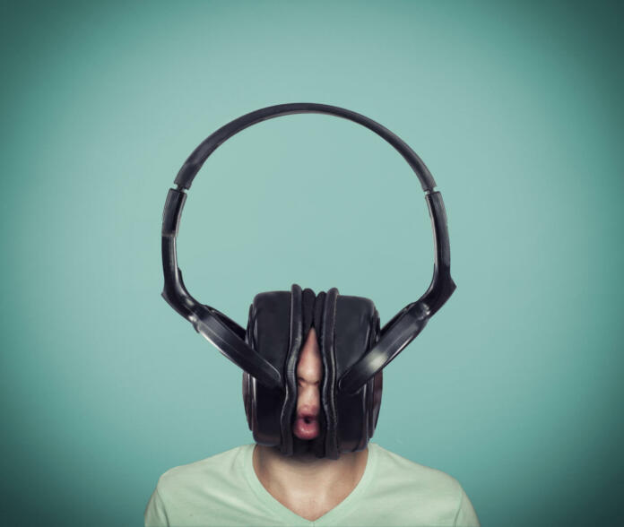 Man listening music on huge headphones .