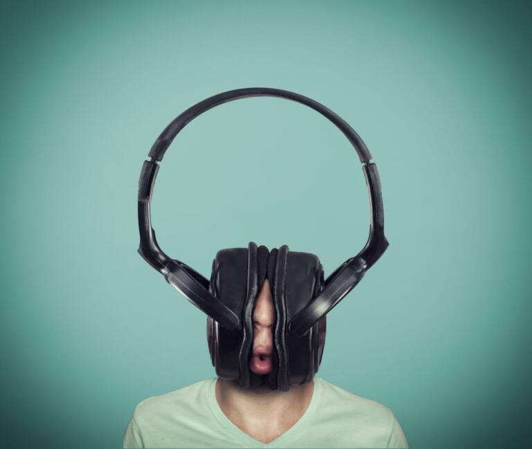Man listening music on huge headphones .