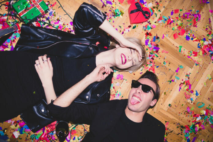 New Year's / Birthday Party. Girl and boy laying on the floor full of confetti