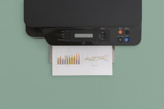 Printer on green background. Top view with copy space. Flat lay.