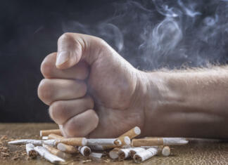 Prihaja popolna prepoved nakupa tobačnih izdelkov Quit smoking man fist crushing cigarettes stop smoking concept on dark background