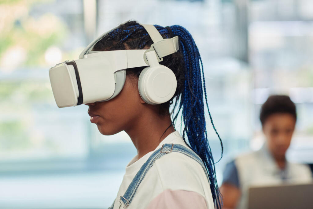 Side view portrait of black teenage girl using VR technology in engineering class