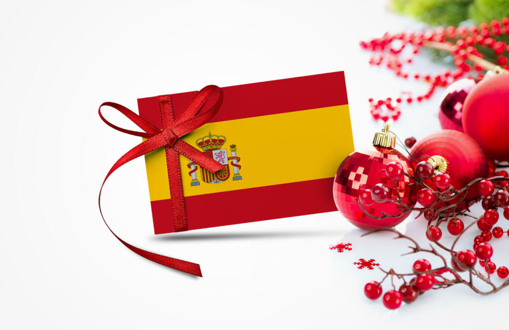 Spain flag on new year invitation card with red christmas ornaments concept. National happy new year composition.