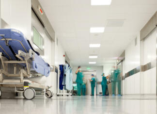 Strašna napaka zdravniške ordinacije Blurred figures of people with medical uniforms in hospital corridor