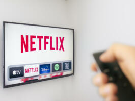 Calgary, Alberta. Canada Dec 9 2019: A Person holds an Apple TV remote using the new Netflix app with a hand. Netflix dominates Golden Globe Nominations. Illustrative
