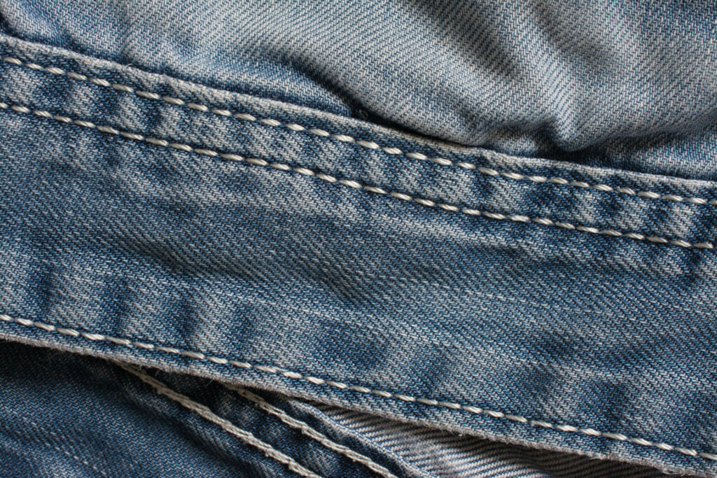 Denim jeans texture, cotton fabric. Pocket and rivet. Textile background