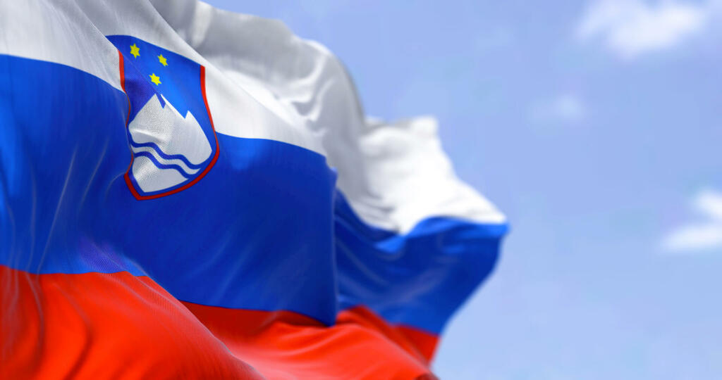 Detail of the national flag of Slovenia waving in the wind on a clear day. Slovenia is a country in Central Europe. Selective focus.
