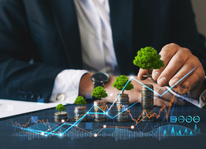 Eco business investment. Green business growth. Businessman holding coin with tree growing on money coin stack. Finance sustainable development.Concept of pass and increase of renewable energy