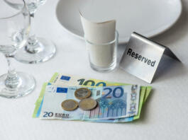 European union currency on a table with receipt bill, wine glasses, plate in restaurant in Europe
