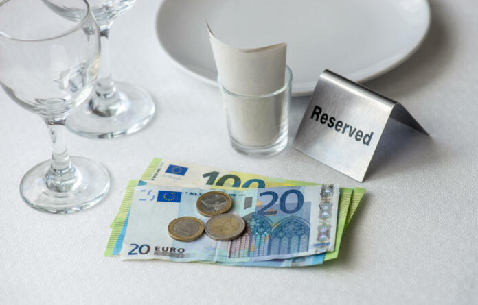 European union currency on a table with receipt bill, wine glasses, plate in restaurant in Europe