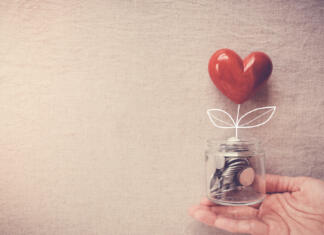 Srčna UL: Za študente v stiski je “srčna ul” zbrala 12 tisoč evrov Hand holding a jar of heart tree growing on money coins, social responsibility and donation concept