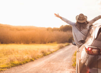 Top 5 idej za predizpitno potovanje Happy girl celebrating success at sunset. The girl is wearing a hat and her arms are outstretched.
