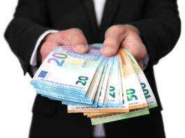 Man giving or offering money. Businessman holding euro banknotes or cash money isolated on white background. High quality photo