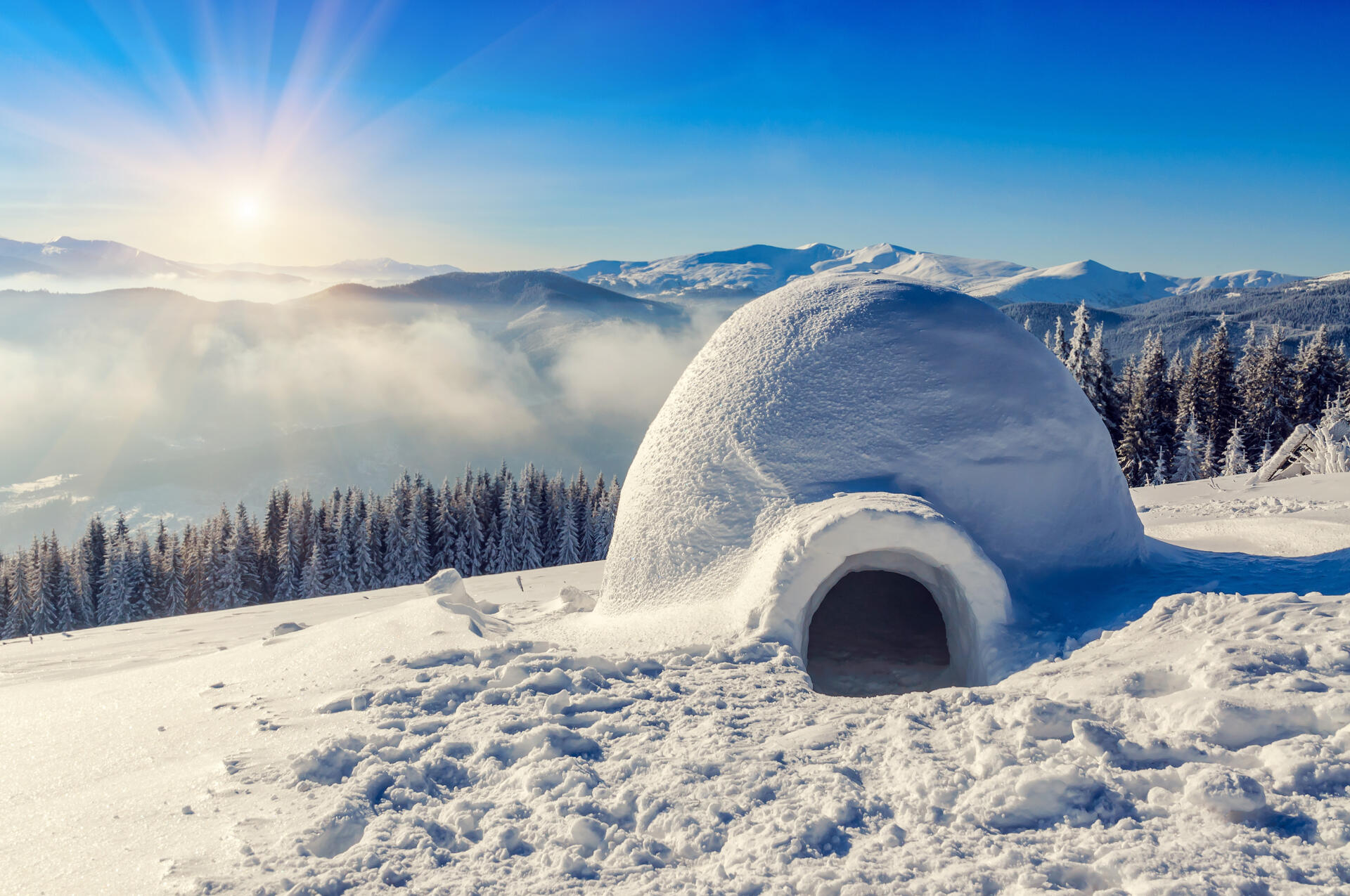 real snow igloo in the mountains under blue sky and sun