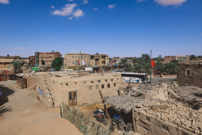 Siwa, Egypt - November 03, 2021: Cityscape View with Old Cars, Local People and Buildings in the Siwa Oasis between the Qattara Depression and the Great Sand Sea in the Western Desert