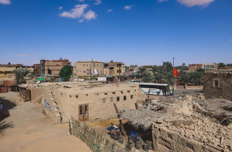 Siwa, Egypt - November 03, 2021: Cityscape View with Old Cars, Local People and Buildings in the Siwa Oasis between the Qattara Depression and the Great Sand Sea in the Western Desert