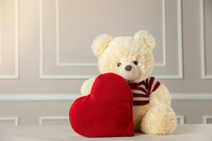 A view of a stuffed teddy bear holding a heart - valentine's concept