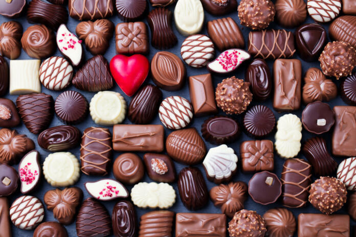 Assortment of fine chocolate candies, white, dark, and milk chocolate Sweets background. Copy space. Top view.