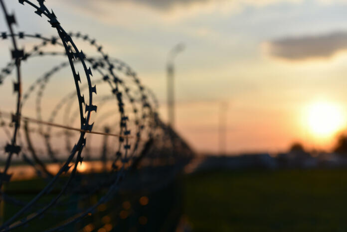 barbed wire fence on the fence on sunset background