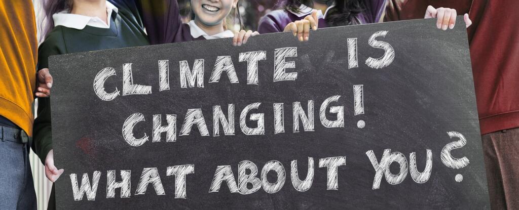 Napis na protestni tabli: CLIMATE IS CHANGING! WHAT ABOUT YOU?