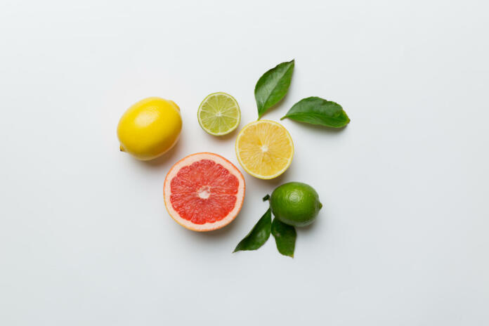 Fruit background. Colorful fresh fruits on colored table. Orange, lemon, grapefruit Space for text healthy concept. Flat lay, top view, copy space.