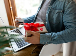 Man using laptop computer and credit card, ordering gifts for Valentines day, Womans Day, Christmas. Shopping online during holidays