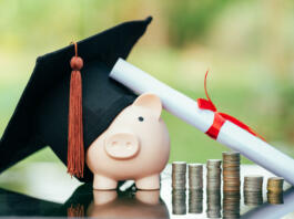 piggy bank With Graduation Cap on black glass floor,Money saving concept.