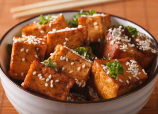 Top 3 recepti s tofujem Stir fry tofu with sesame seeds and herbs in a bowl close-up. horizontal