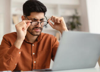 Kakšno je pravilno citiranje v slovenščini? Young male freelancer with bad eyesight using laptop, trying to work from home. Middle Eastern guy holding and taking off his glasses and squinting, looking at laptop screen, having vision troubles