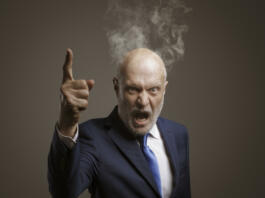 Angry boss shouting at camera, he is scolding an employee