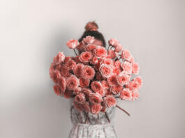 Bouquet in female hands. Bunch of Living Coral roses. Color of year 2019 Living Coral concept.