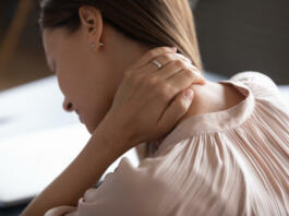 Close up exhausted woman touching massaging tensed neck muscles, feeling unwell after long hours sedentary work, uncomfortable chair, incorrect posture, young female suffering from pain, ache
