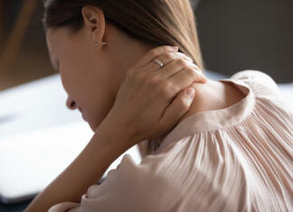 Imam namišljeno bolezen, fibromialgijo… Close up exhausted woman touching massaging tensed neck muscles, feeling unwell after long hours sedentary work, uncomfortable chair, incorrect posture, young female suffering from pain, ache